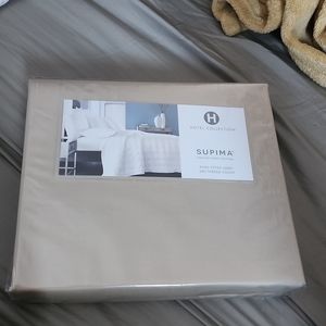 New in package hotel collection supima fitted sheet for king size bed. Tan